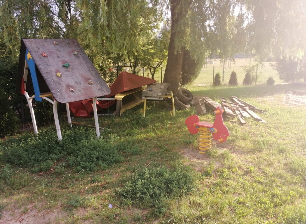 zdemontowana ściana wspinaczkowa i zjeżdżalnia leżą po lewej stronie drzewa