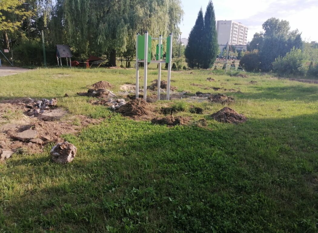 na trawie wykopane dołki i pozostałości po zjeżdżalni