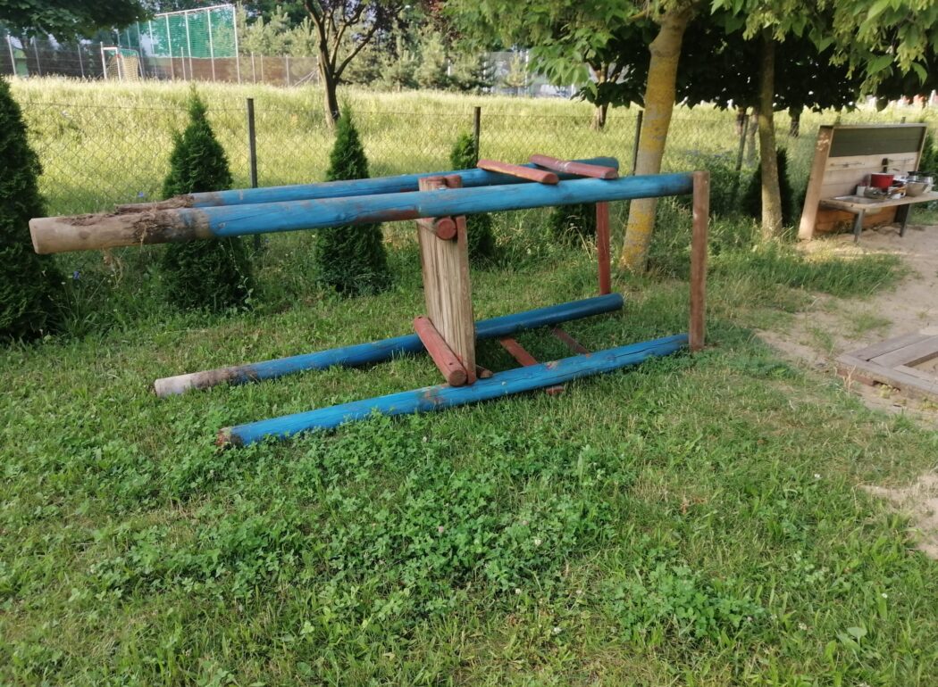 na trawie leży zdemontowana wieża od zjeżdżalni
