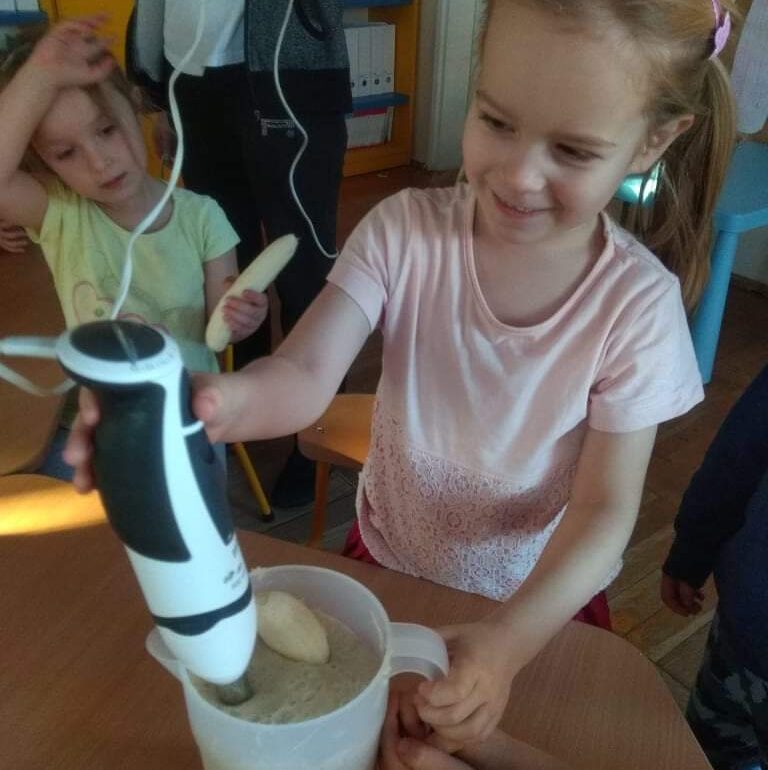 Uśmiechnięta dziewczynka trzyma blender