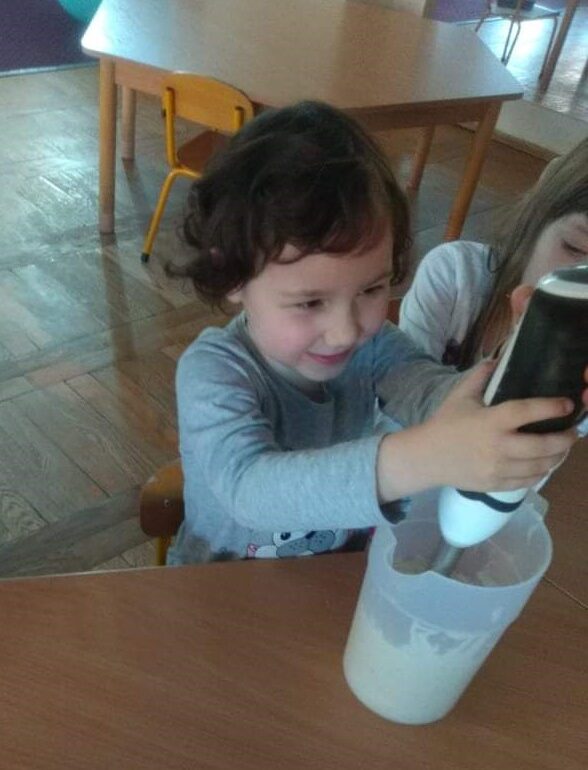 Uśmiechnięta dziewczynak trzyma blender