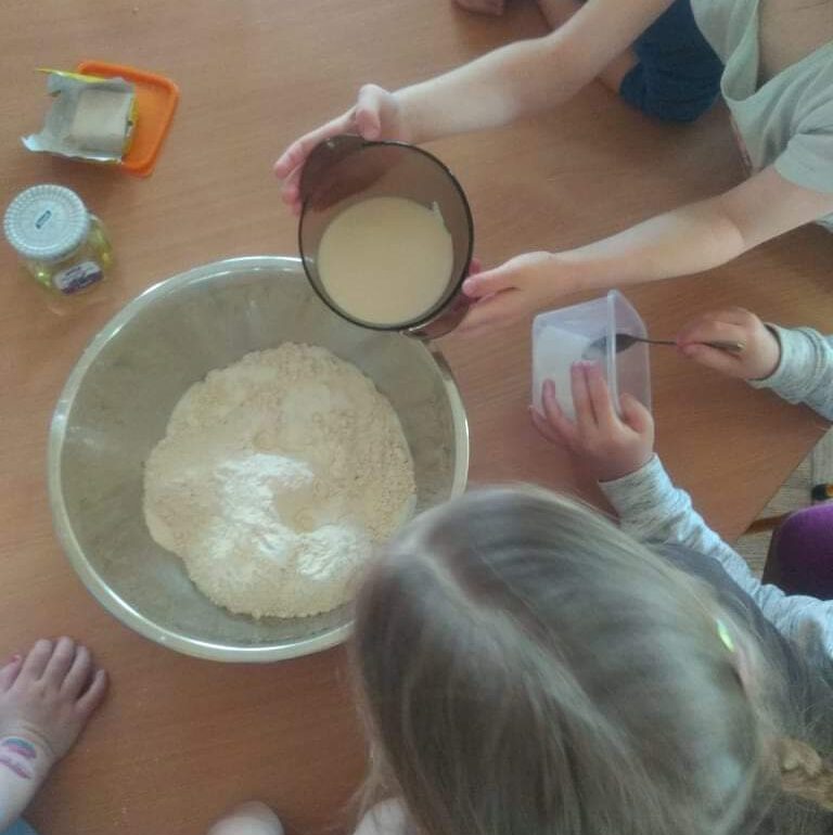 dzieci wlewają do miski maślankę