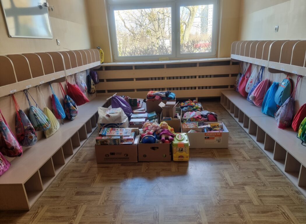 na podłodze leżą kartony z zabawkami, kocami