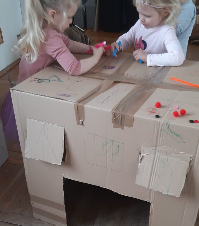 dzieci przyklejają naklejki na karton
