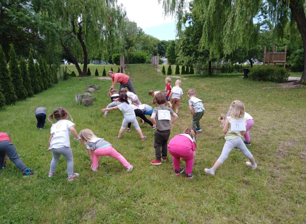dzieci gimnastykują się na trawie